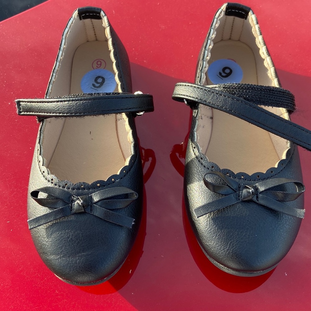 Toddler girls black dress goes with a bow on the top. Velcro strap